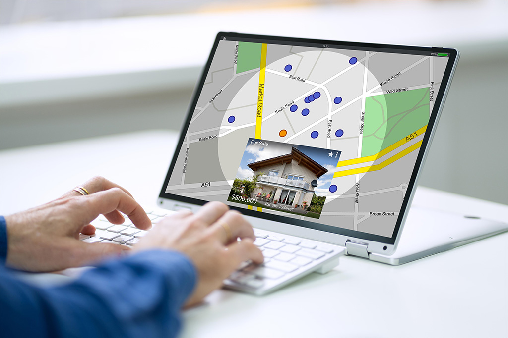 Owner reviewing rental properties on a map on a laptop